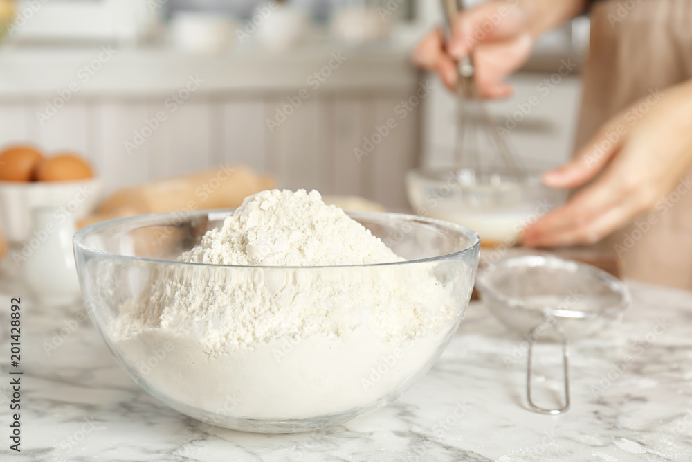Bowl with flour and woman on background Bowl with flour and woman on background