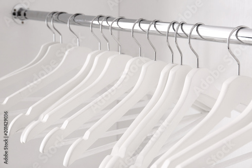 Clothes rail with hangers in wardrobe