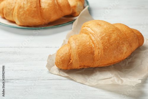 Tasty croissant on wooden table