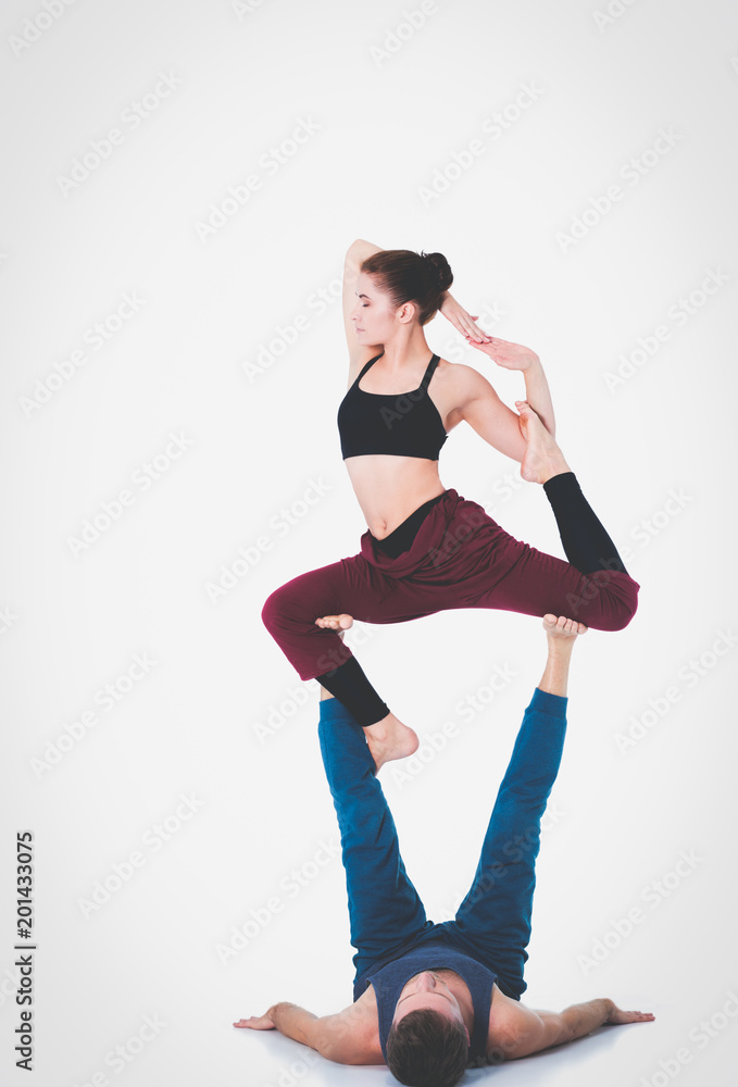 Young athletic couple practicing acroyoga. Balancing in pair. Young athletic couple practicing acroyoga. Balancing in pair.