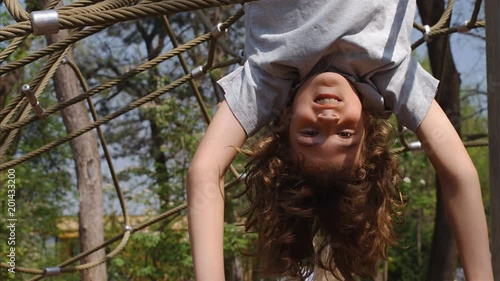 Slow motion of 10 years old boy hanging upside down on jungle gym, 4k