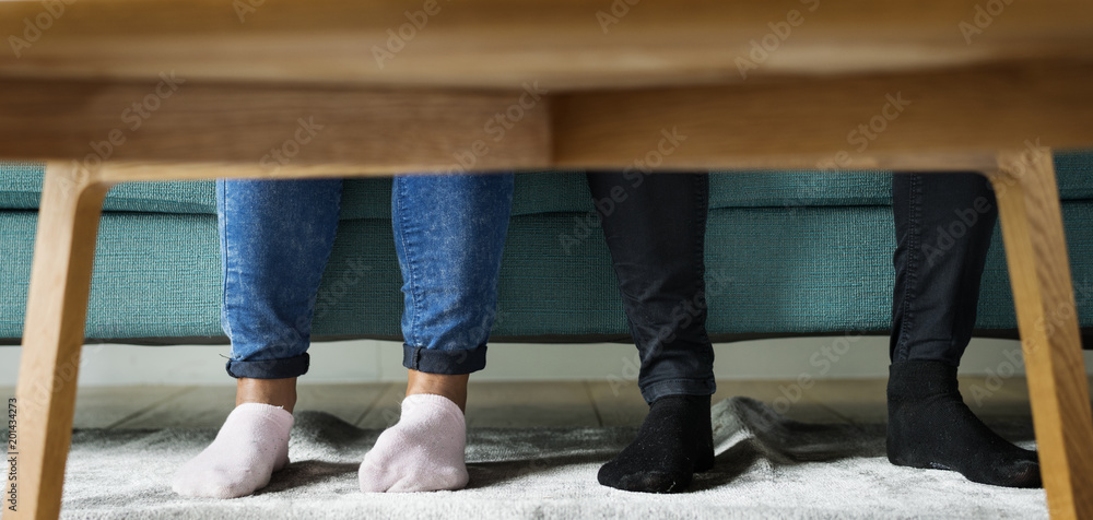 © Rawpixel.com - Feet sticking out under a sofa table © Rawpixel.com - Feet sticking out under a sofa table