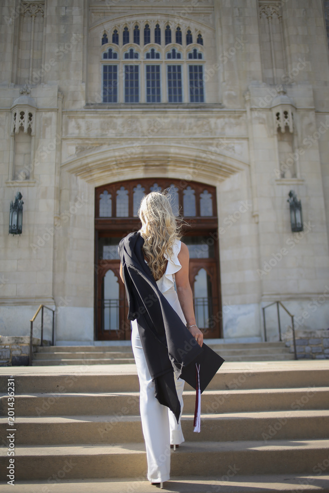 College Graduation Concept Young Woman in a White Jumpsuit Ascending Stairs  of a University with her Commencement Cap and Gown Stock Photo | Adobe Stock