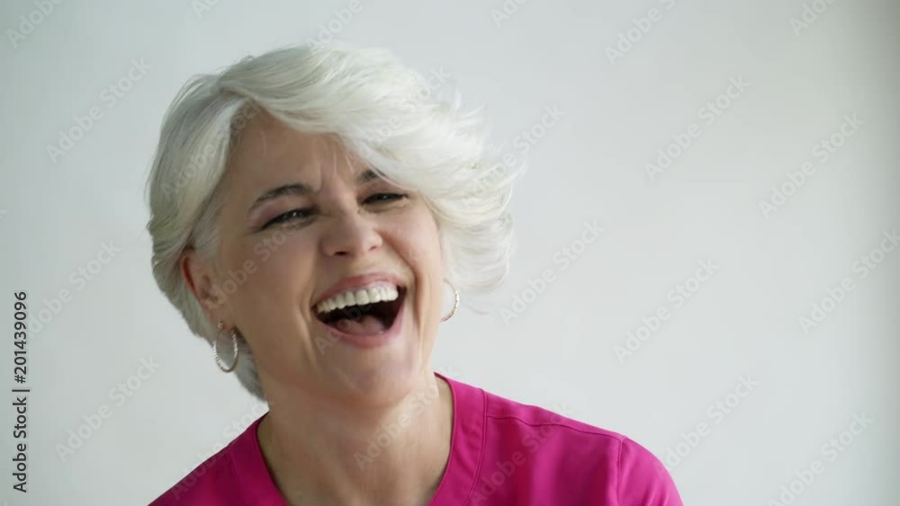 Woman with short hair laughing and nodding, studio shot. Woman with short hair laughing and nodding, studio shot.