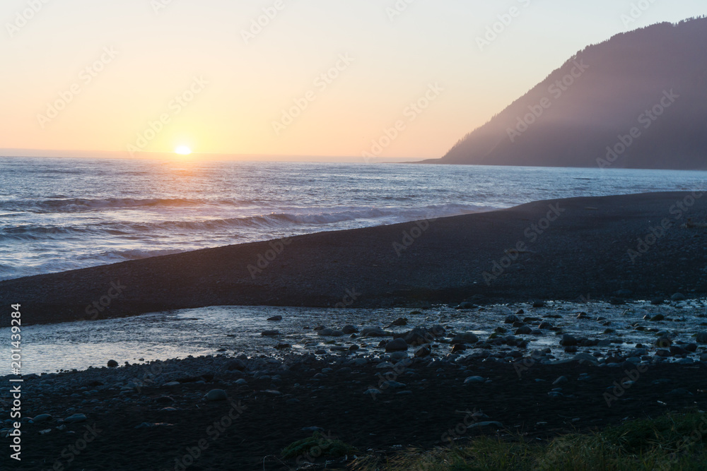A colorful beach sunset over the black sands of the Lost Coast backpacking trail in California A colorful beach sunset over the black sands of the Lost Coast backpacking trail in California