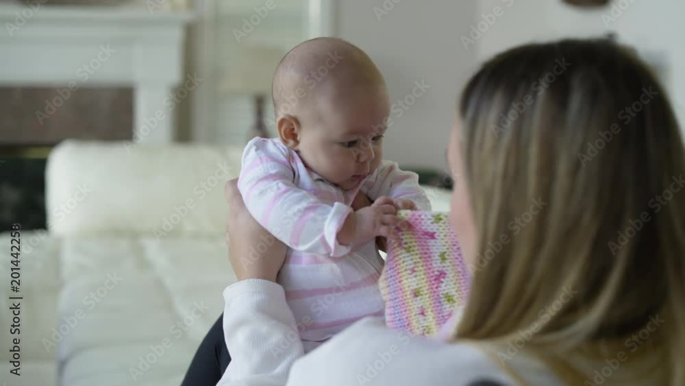 Mother and baby daughter lying on sofa with knitted blanket. Mother and baby daughter lying on sofa with knitted blanket.