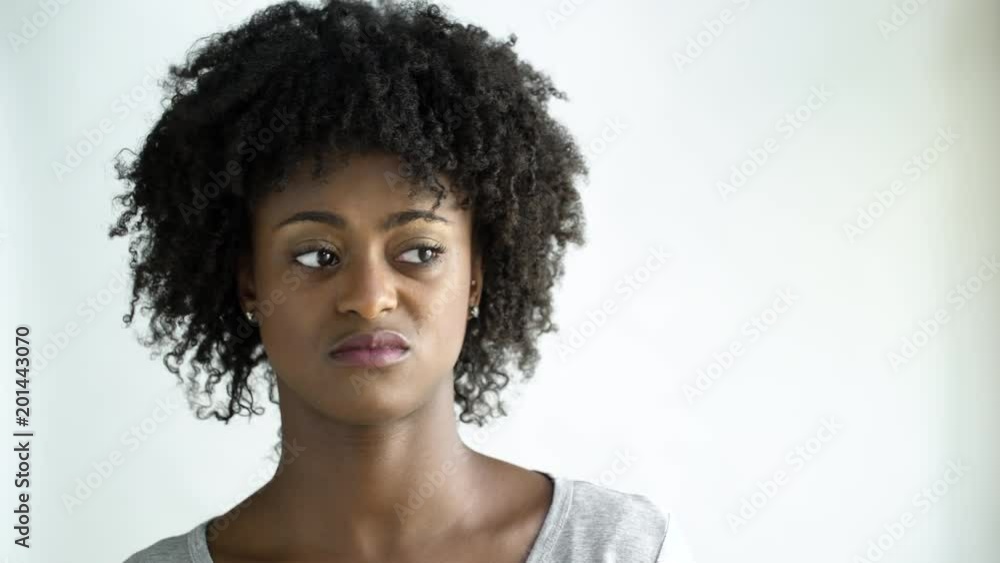 Displeased young woman with afro, studio shot. Displeased young woman with afro, studio shot.