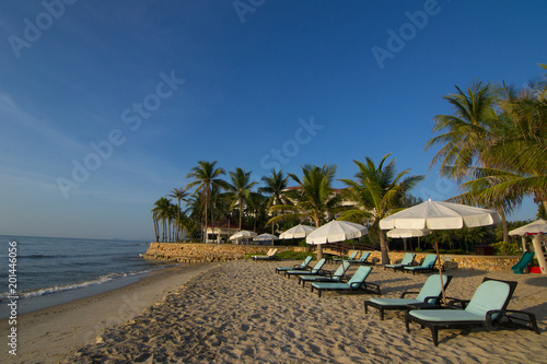 Beach loungers on the deserted coast sea at sunrise. © dekliyngkaea