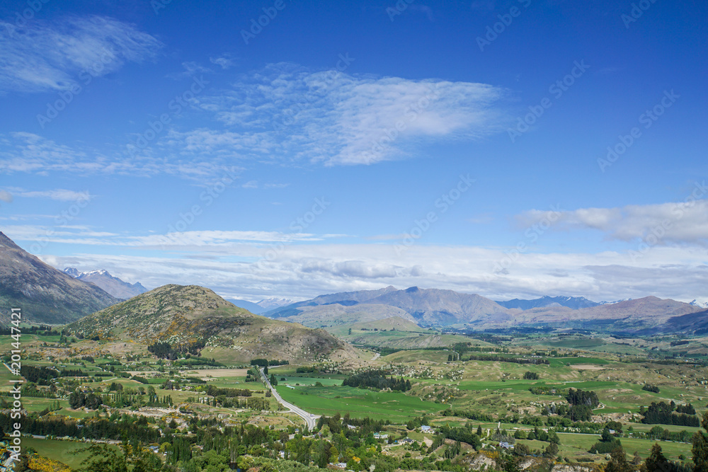 panorama bird eye view of cityscape in Queenstown New Zealand with mountain range in sunny blue sky