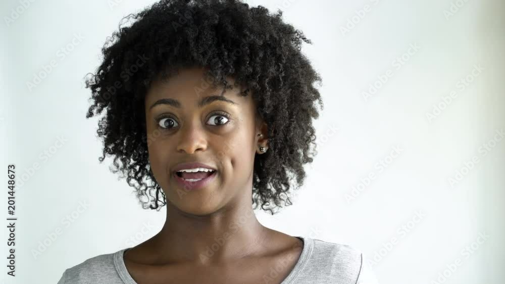 Surprised young woman with afro smiling , studio shot. Surprised young woman with afro smiling , studio shot.