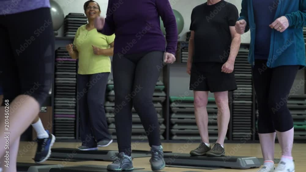 Small group of people doing step aerobics Small group of people doing step aerobics