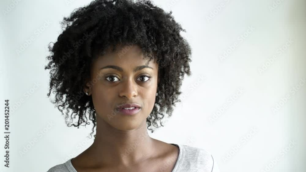 Young woman with afro smiling , studio shot. Young woman with afro smiling , studio shot.