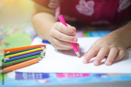 Children draw on white paper.