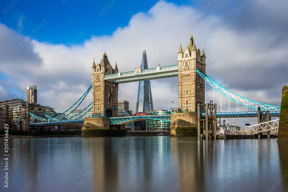 Fototapeta premium London, England - Iconic Tower Bridge at sunrise with red double-decker bus on it and Shard skyscraper at background