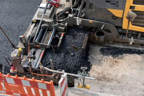 Asphaltfertiger verteilt über den Schneckenkanal heißen Asphalt, verdichtet und glättet diesen, top view