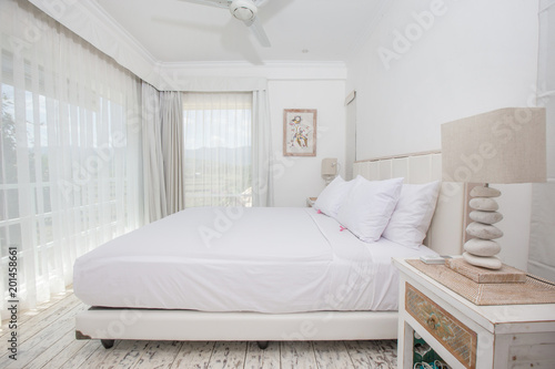 Bright light white clean stylish interior bedroom with a large panoramic window beautiful view