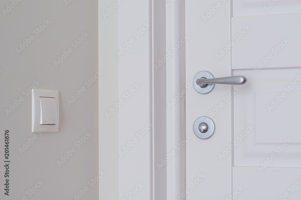 White interior door. Beige switch on light wall White interior door. Beige switch on light wall