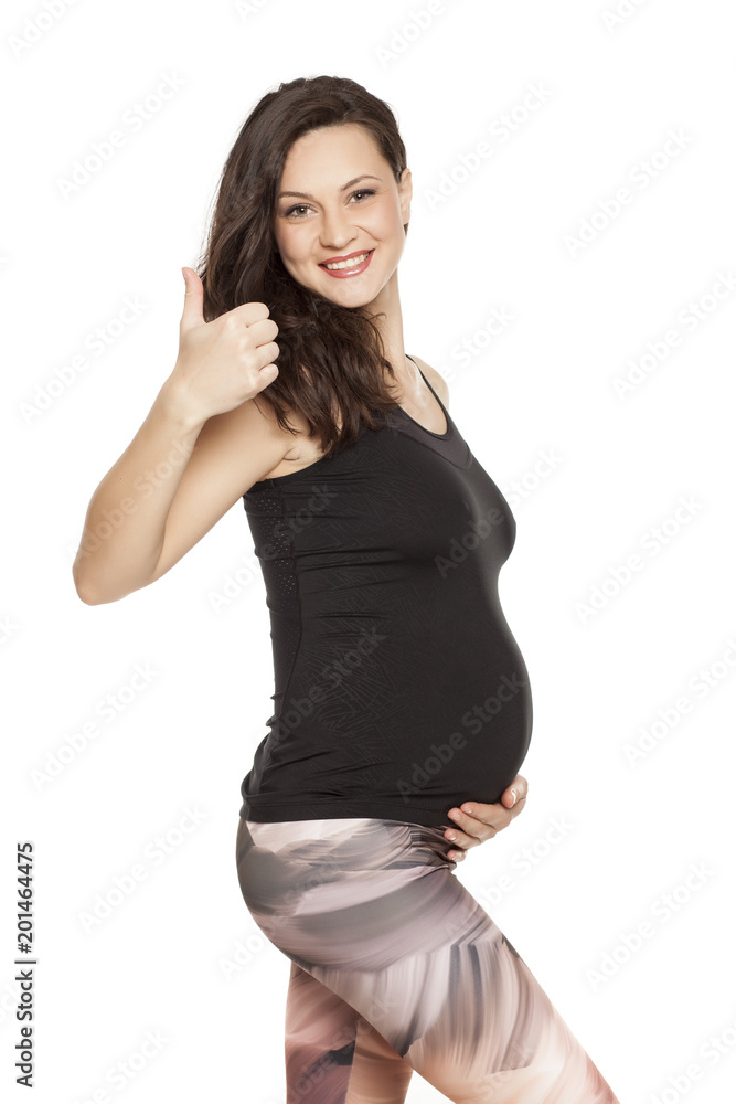 Beautiful smiling pregnant woman posing on white background, and show thumbs up Beautiful smiling pregnant woman posing on white background, and show thumbs up