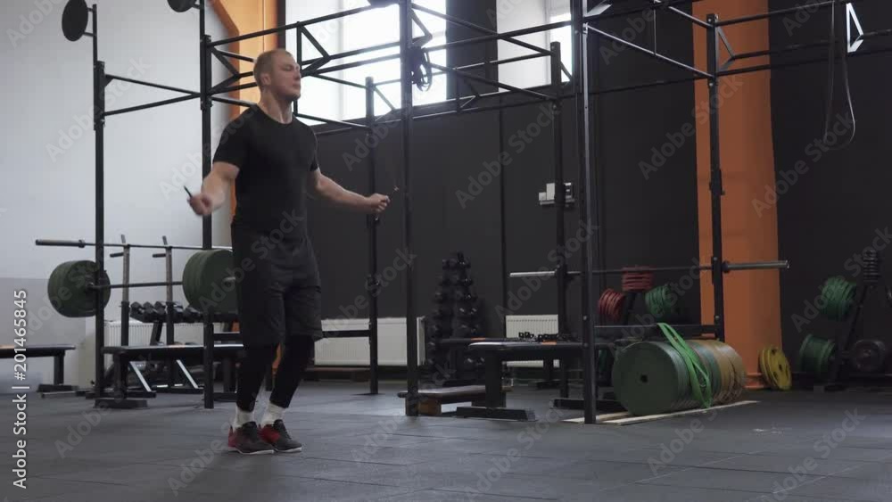 Fitness man doing double jumps rope exercise in gym Fitness man doing double jumps rope exercise in gym