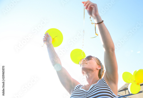girl striped dress outside balloons yellow sky sun
