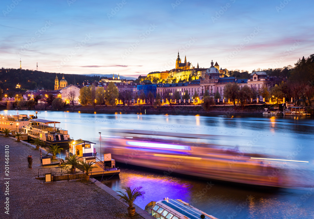 Fototapeta premium Boat on the Vltava at night with St. Vitus Cathedral in the background, Prague