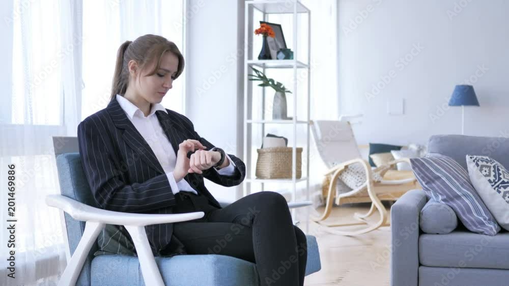 Woman Using Smartwatch while Sitting on Sofa Woman Using Smartwatch while Sitting on Sofa