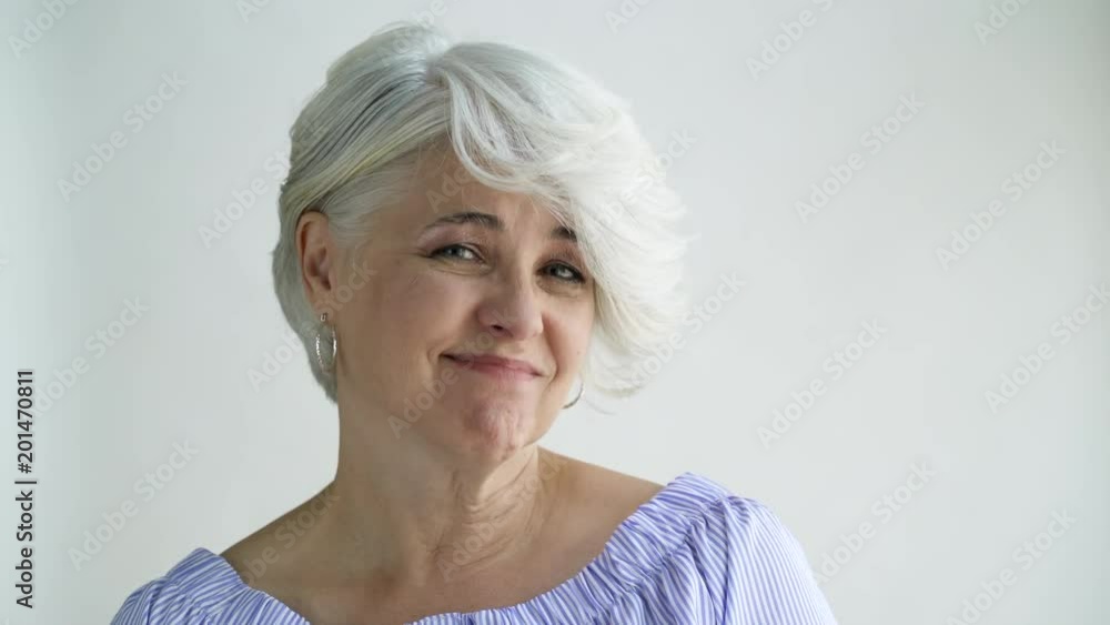 Woman with short hair shaking and nodding her head, studio shot. Woman with short hair shaking and nodding her head, studio shot.