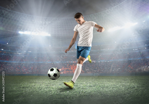 Obraz na plátne Soccer player on a football field in dynamic action at summer da