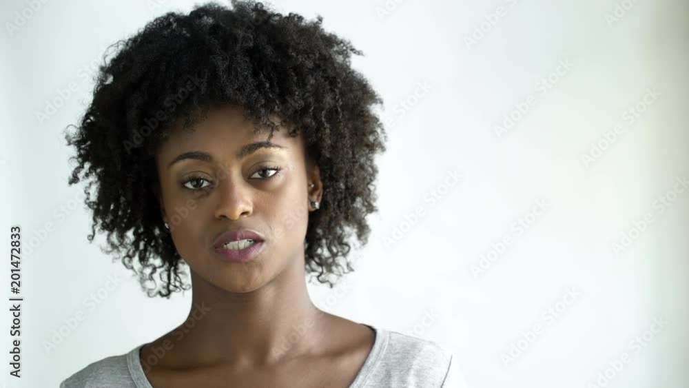 Displeased young woman with afro, studio shot. Displeased young woman with afro, studio shot.