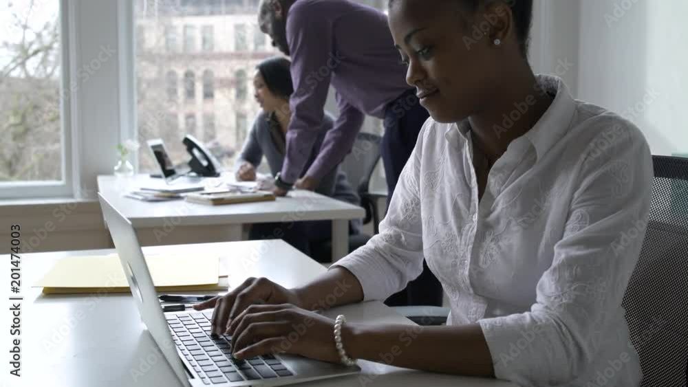 Young women and a man working in an office Young women and a man working in an office