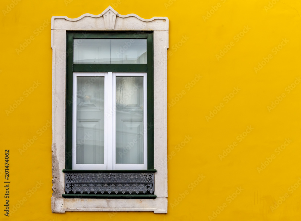 Window on yellow facade building during afternoon journey