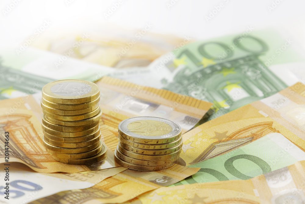 Euro coins in pile on Euro banknotes, background. Euro coins in pile on Euro banknotes, background.