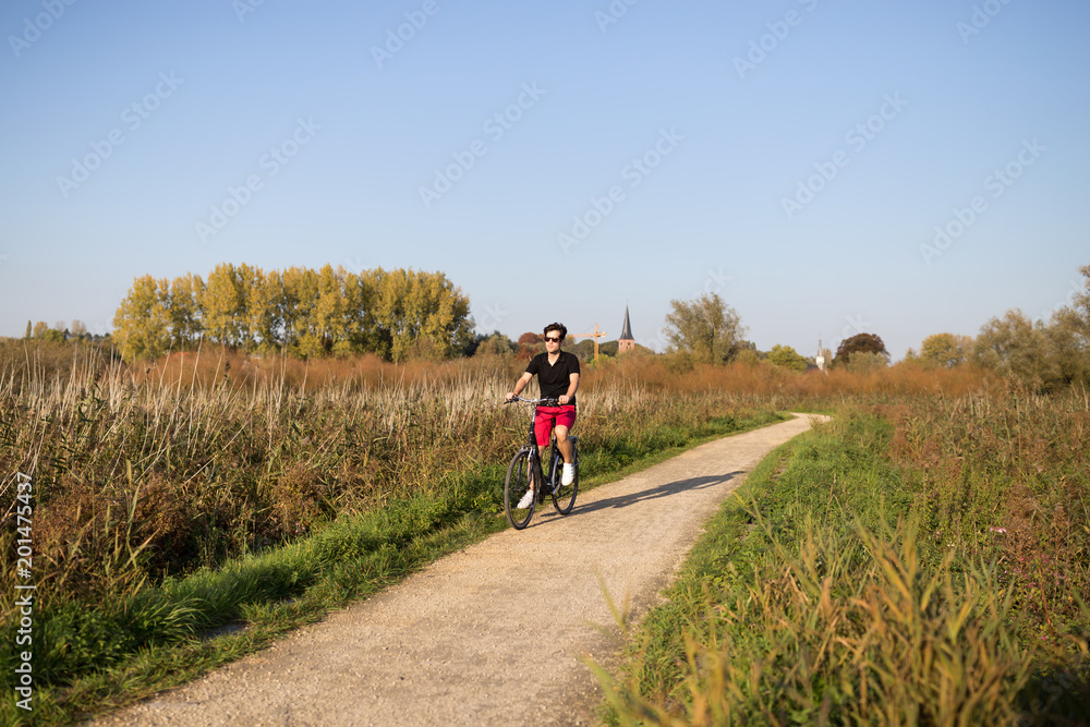 Young man enjoying a ride on his bicycle in nature Young man enjoying a ride on his bicycle in nature