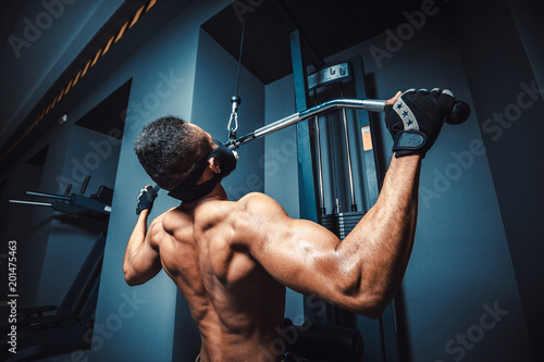 Bilde på lerret african american athletic man doing exercise in pull down machine back view