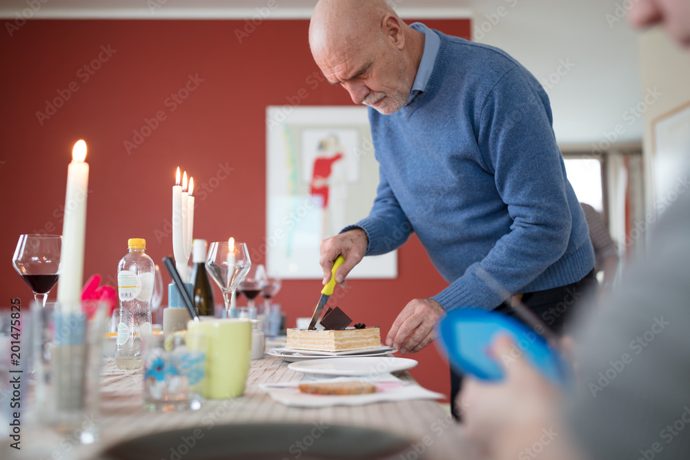 Grandfather cutting birthday cake on table Grandfather cutting birthday cake on table