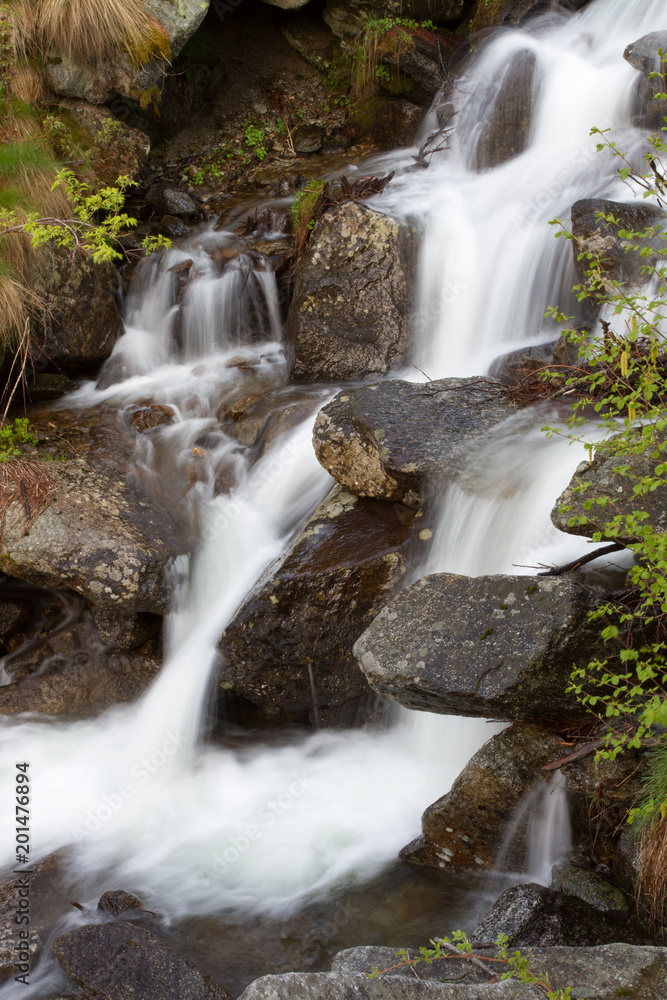 Small waterfall of a creek downhill to the Gran Paradiso National Park Small waterfall of a creek downhill to the Gran Paradiso National Park