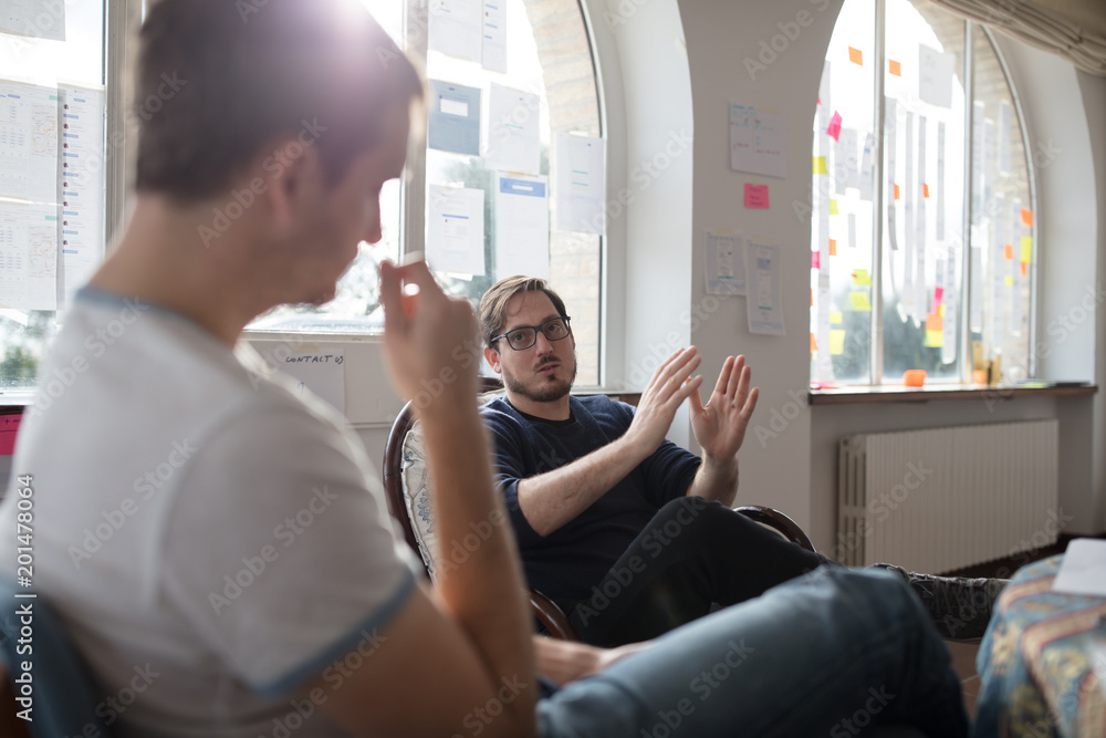 Coworkers talking with each other in office Coworkers talking with each other in office