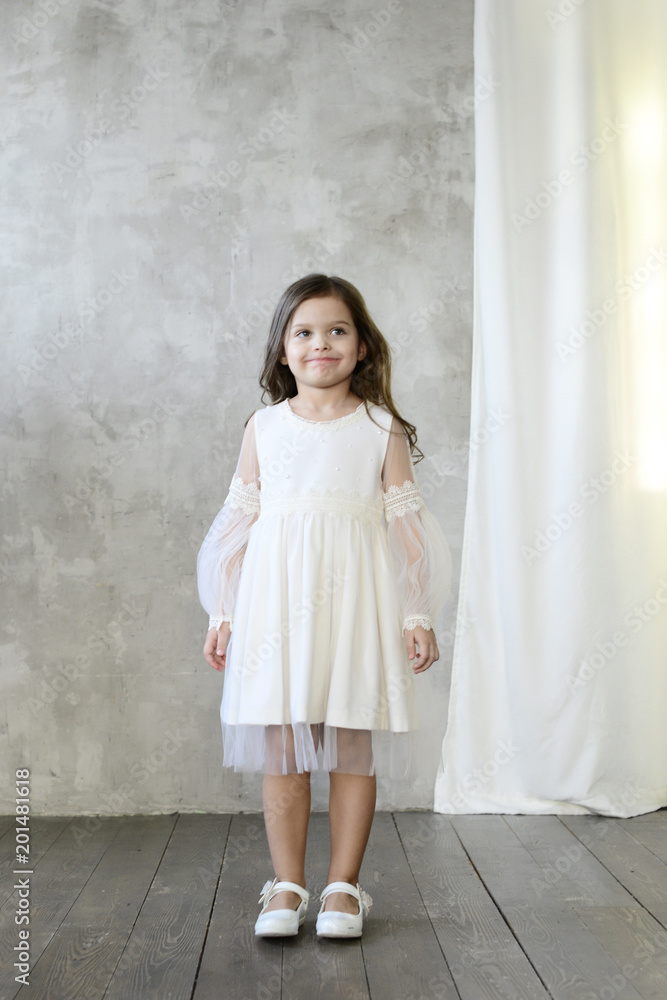 Children's fashion. Little stylish girl in white dress. Children's fashion. Little stylish girl in white dress.