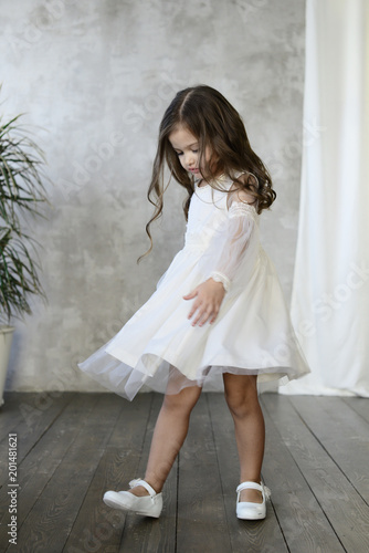 Children's fashion. Little stylish girl in white dress.