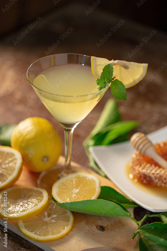 Lemon juice with honey on wooden table, lemons and sage leaves Lemon juice with honey on wooden table, lemons and sage leaves