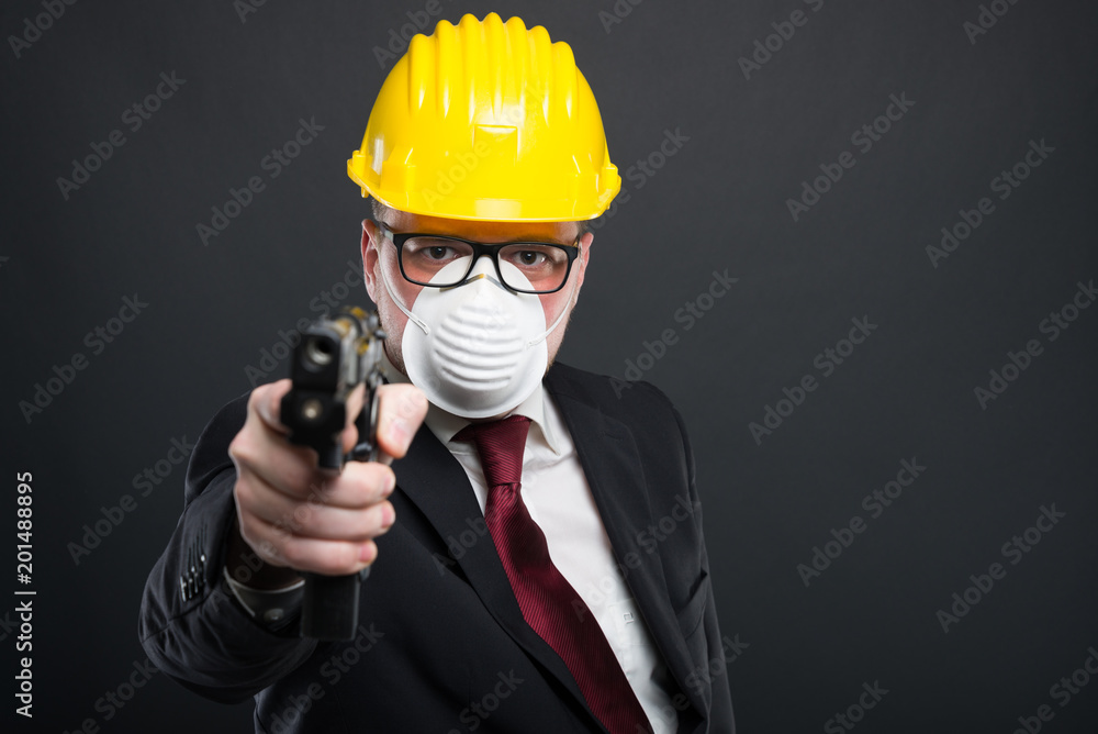 Business man wearing hardhat and mask holding gun. Business man wearing hardhat and mask holding gun.