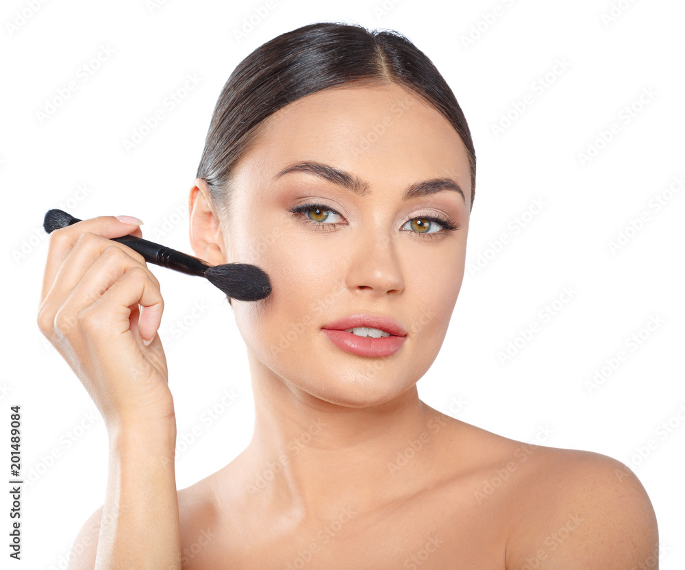 Beauty portrait of a playful beautiful half naked woman applying make-up with a brush