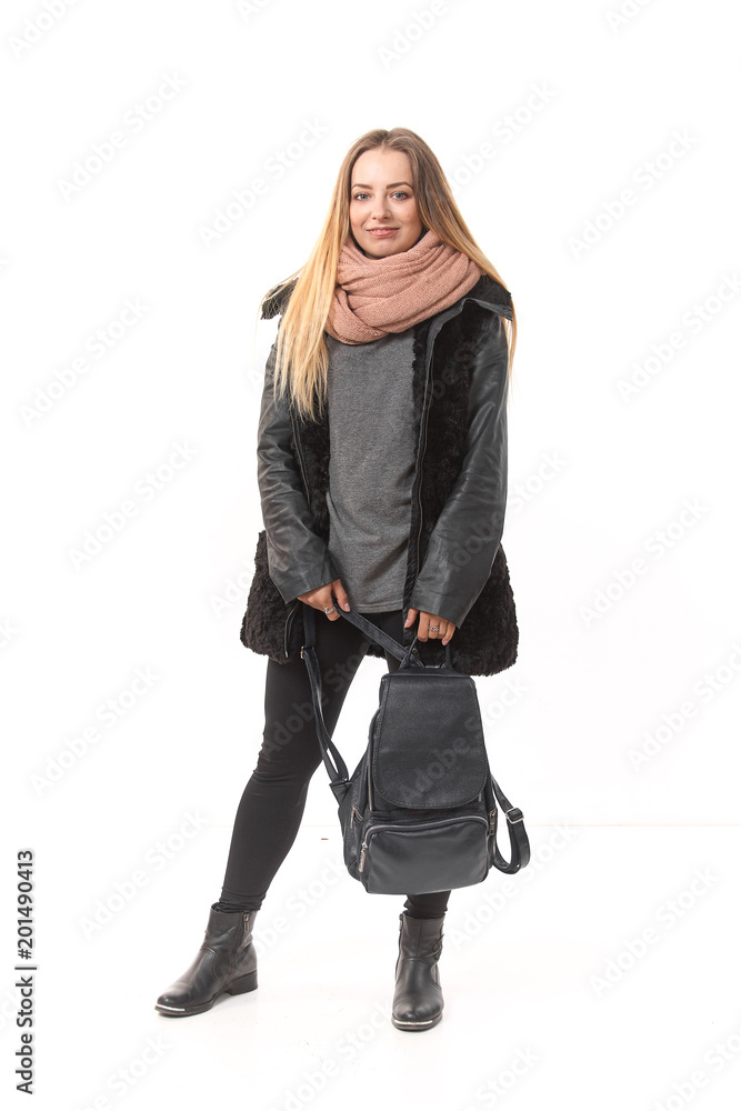 Fototapeta premium A girl in demi-season clothes with a full-length bag on a white background.