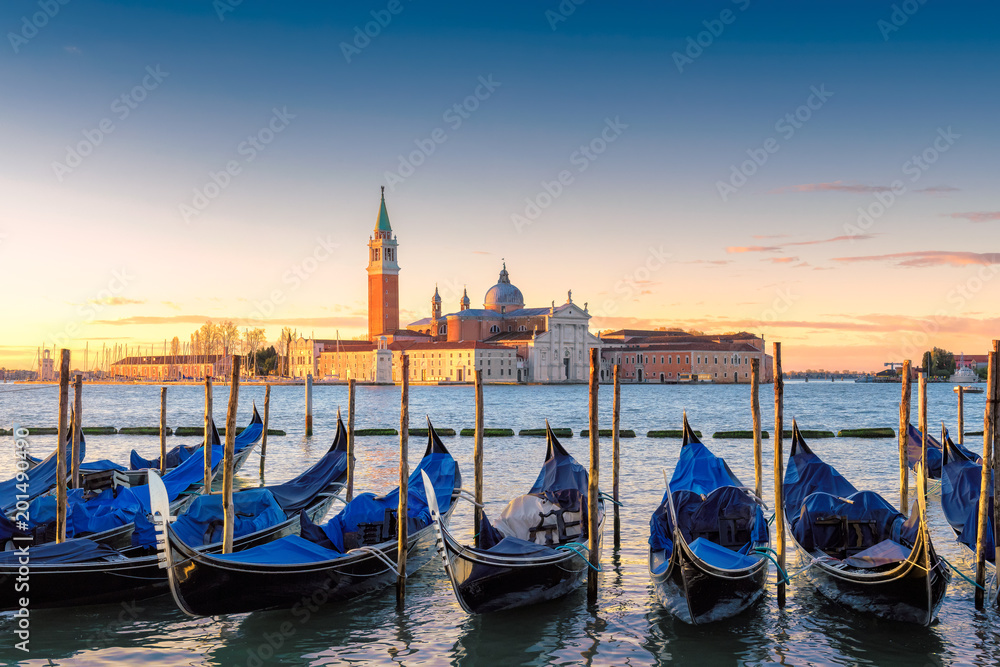 Venetian gondolas at sunrise on Grand Canal by San Marco square, Venice, Italy. 