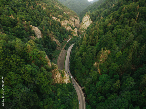 aerial view of road in beautiful mountain forest with railroad