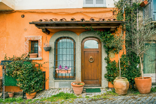 фотографія facade of beautiful building with potted plants and flowers in Castel Gandolfo,