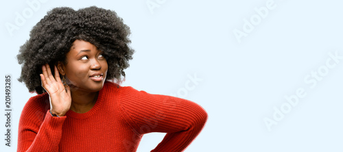 Photography Beautiful african woman holding hand near ear trying to listen to interesting ne