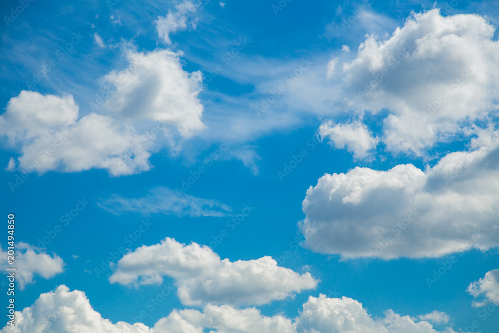 Naklejka premium Beautiful bright blue sky with white fluffy clouds background. Horizontal color photography.