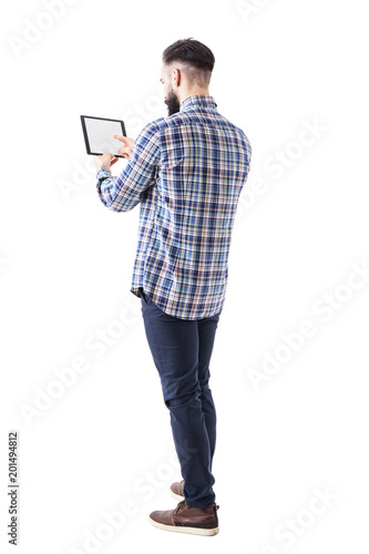 Rear side view of bearded business man pushing button on tablet computer blank touch screen. Full body isolated on white background. 