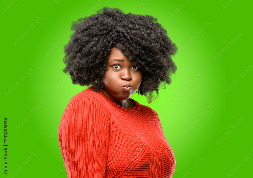 Beautiful african woman puffing out cheeks, having fun making funny face Beautiful african woman puffing out cheeks, having fun making funny face